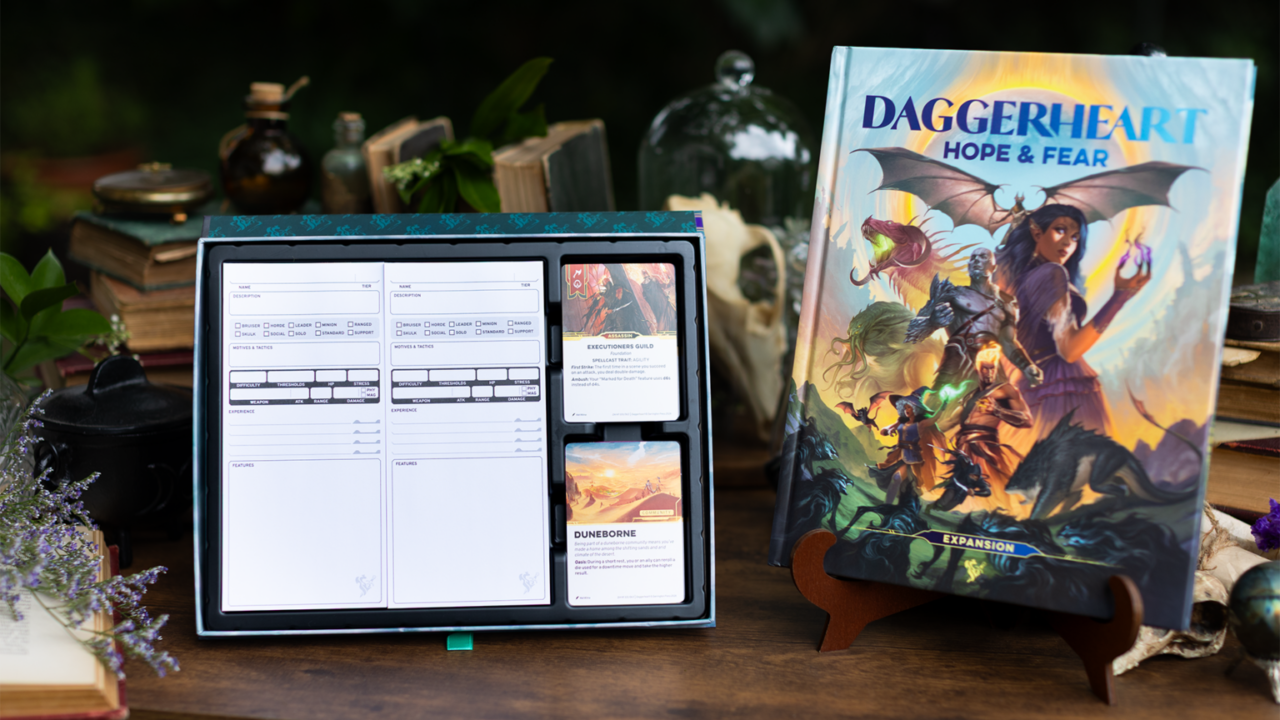 Livro e cartas da expansão Daggerheart Hope & Fear dispostos sobre uma mesa de madeira