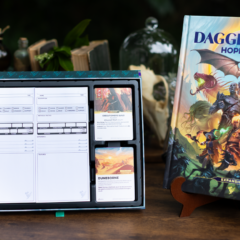 Livro e cartas da expansão Daggerheart Hope & Fear dispostos sobre uma mesa de madeira